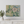 Abstract painting on a wall above a white console table with decorative items.

