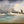 Painting of a person walking on water surrounded by rough seas and dark clouds.