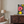 Floral painting on a wall above a wooden cabinet in a living room.