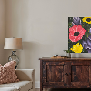 Floral painting on a wall above a wooden cabinet in a living room.