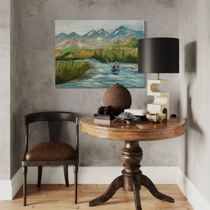 Room interior with a wooden table, chair, lamp, and painting of a mountain landscape.