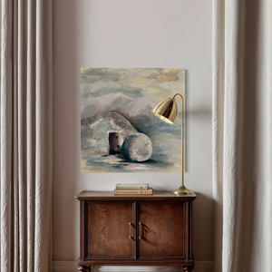 Decorative interior scene with a painting, lamp, and wooden cabinet against a light wall.